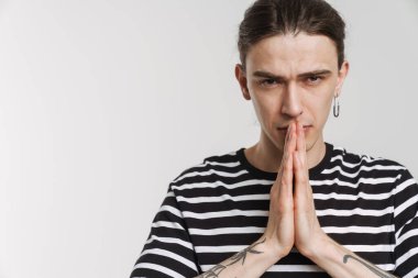 Beyaz arka planda el ele tutuşurken kameraya bakan genç beyaz adam.