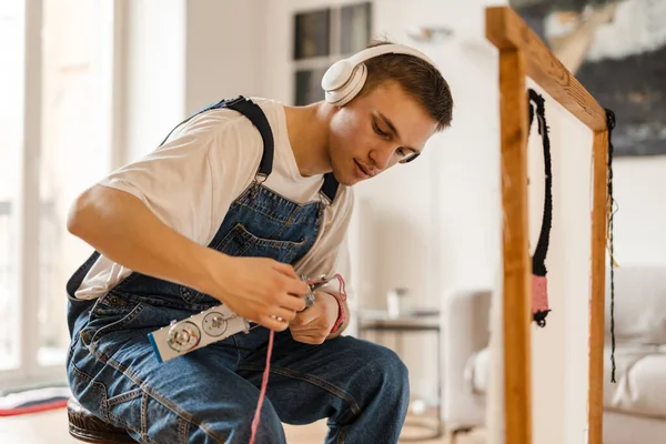 Mladý Bílý Muž Sluchátkách Pracuje Řemeslné Koberec Šicí Stroj Doma — Stock fotografie