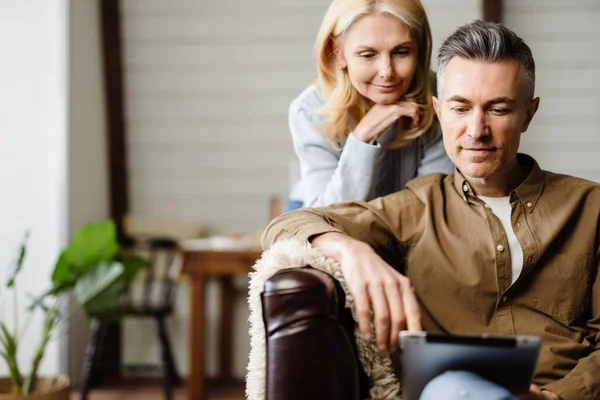 Sonriente Pareja Blanca Mediana Edad Que Relaja Sofá Casa Utilizando — Foto de Stock