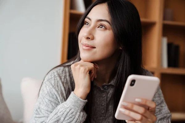 Attraktive Nachdenkliche Junge Frau Nutzt Handy Während Sie Sich Hause — Stockfoto