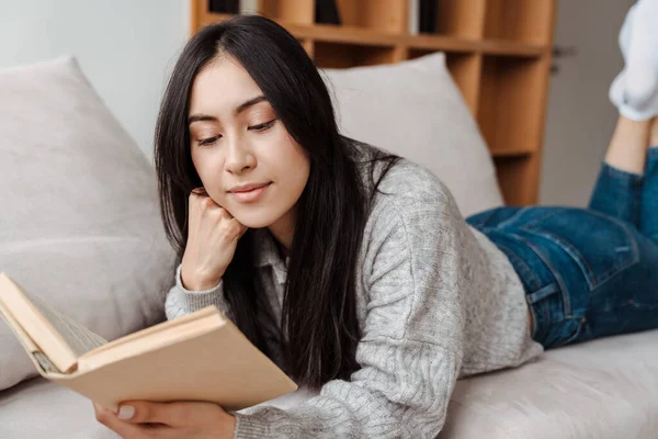 Giovane Donna Felice Lettura Libro Mentre Seduto Sul Divano Soggiorno — Foto Stock