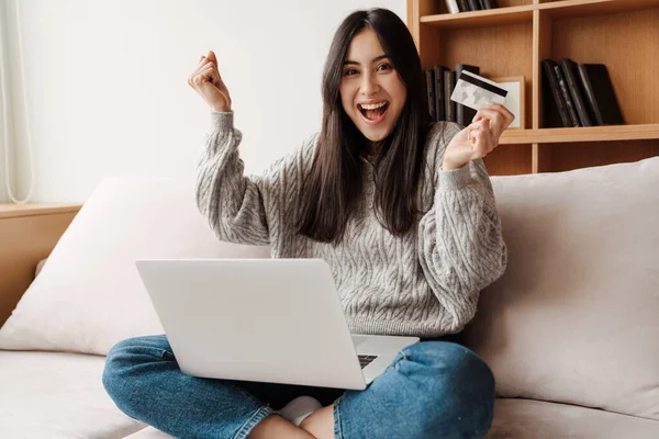 ラップトップコンピュータを介してオンラインで幸せな若い魅力的な女性のショッピング 自宅でクレジットカードを使用して — ストック写真