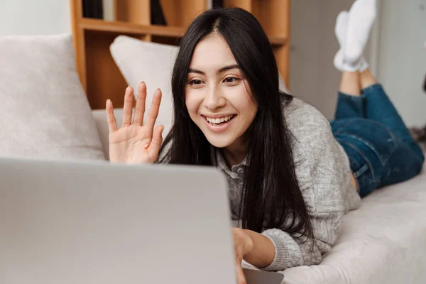 Glædelig Asiatisk Kvinde Vinker Hånd Bruger Bærbar Computer Mens Hun - Stock-foto