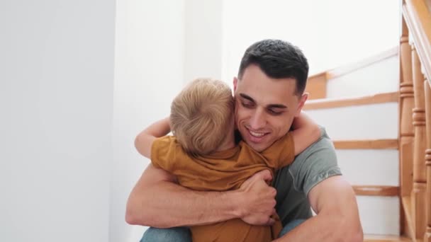 Küçük Oğlunu Kucaklayan Öpen Bir Baba Evdeki Merdivenlerde Oturuyor — Stok video