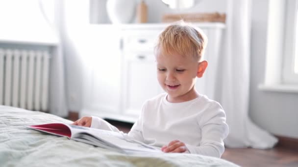 Niño Sonriente Leyendo Libro Casa — Vídeos de Stock