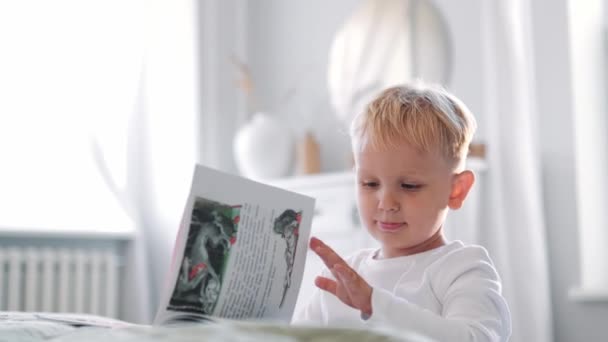 Liten Blond Liten Pojke Som Tittar Boken Stående Sovrummet Hemma — Stockvideo