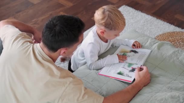 Uma Visão Superior Pai Lendo Livro Com Seu Filho Brincalhão — Vídeo de Stock