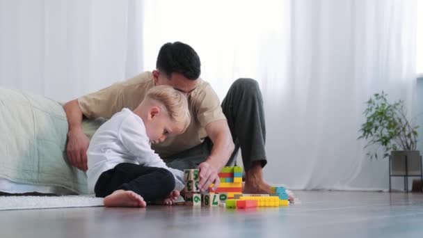 Ένα Μικρό Αγόρι Παίζει Παιχνίδια Τον Πατέρα Του Στο Σπίτι — Αρχείο Βίντεο