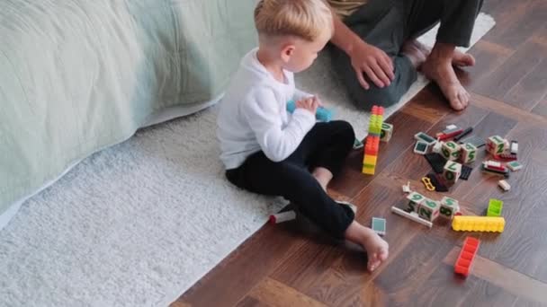 Ένας Μικρός Γιος Παίζει Παιχνίδια Του Στο Πάτωμα Και Πατέρας — Αρχείο Βίντεο