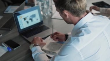 Ofisteki masada otururken dizüstü bilgisayar kullanan bir iş adamının arka planı.