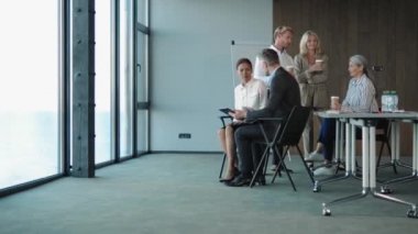 Ofiste oturup birbiriyle konuşan bir grup işçi.