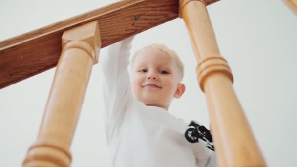 Веселий Маленький Хлопчик Йде Нагору Іграшкою Руці Вдома — стокове відео