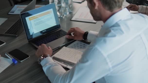 一个商人使用笔记本电脑在办公室桌子旁工作的背景图 — 图库视频影像