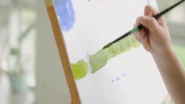 Modern sanat okulundaki resim sehpasına odaklanmış bir öğrenci resmine yakından bakmak.