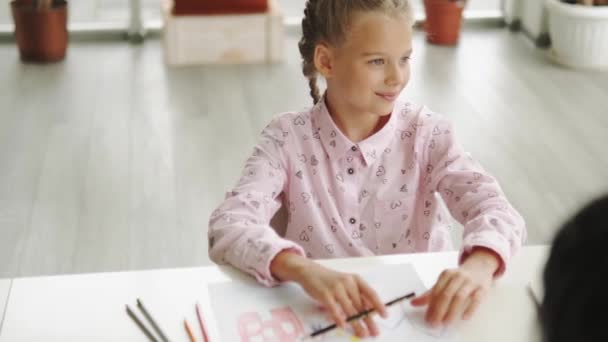 Una Chica Sonriente Sentada Escritorio Mientras Piensa Algo Escuela Arte — Vídeo de stock