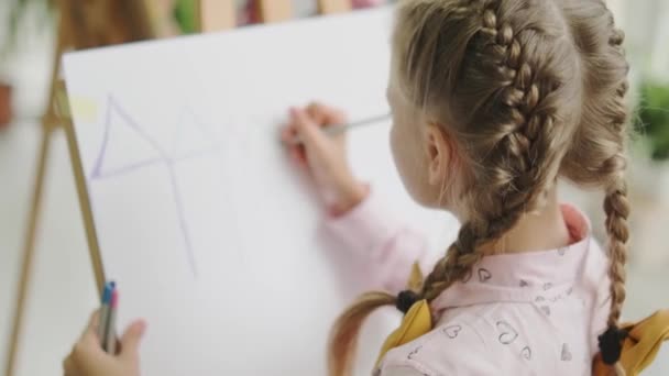 Una Vista Trasera Una Hermosa Niña Pequeña Dibujando Caballete Escuela — Vídeo de stock