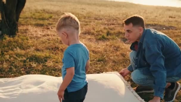 Батько Розсовує Пікнік Його Син Стрибає Ньому Природі — стокове відео