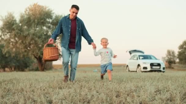 Sorrindo Pai Filho Correndo Com Uma Cesta Piquenique Suas Mãos — Vídeo de Stock