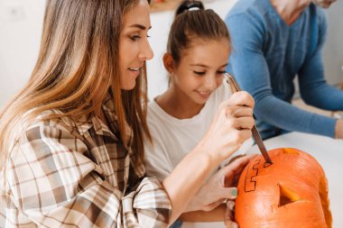 Beyaz anne ve kız Cadılar Bayramı 'nı evde birlikte geçirirken gülümsüyorlar.