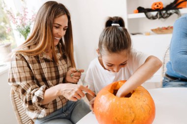 Beyaz anne ve kız Cadılar Bayramı 'nı evde birlikte geçirirken gülümsüyorlar.