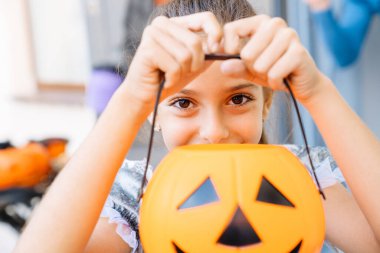 Beyaz kız Cadılar Bayramı 'nda dışarıda şaka mı şeker mi oynarken gülüyor.