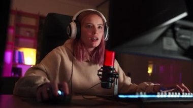 Bilgisayar başında video oyunu oynayan ve zaferle sevinen bir kız oyuncu.