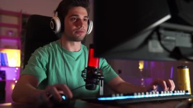 Profesyonel erkek-oyuncu hevesle bilgisayarda oyun oynuyor ve kaybettiği için üzülüyor.