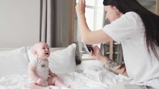 Mamá Tomando Una Foto Bebé Sentado Cama — Vídeos de Stock