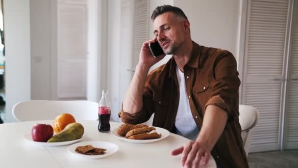 Een Gelukkige Volwassen Man Aan Telefoon Tijdens Het Diner — Stockvideo