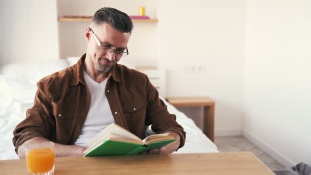 夕食時に本を読む眼鏡のハンサムな成熟した男 — ストック動画