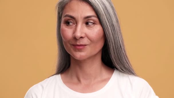 Mutlu Asyalı Olgun Bir Kadın Yan Tarafa Bakıyor Bej Rengi — Stok video