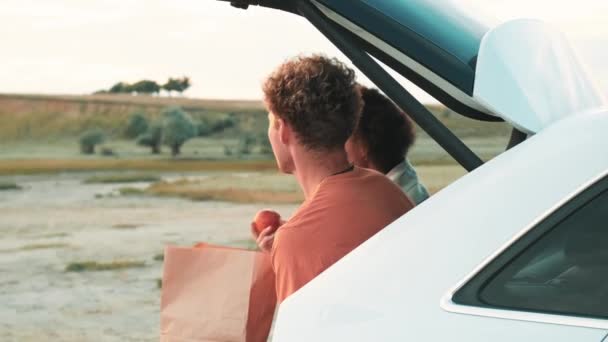Rückansicht Des Multinationalen Paares Das Pfirsiche Isst Während Kofferraum Eines — Stockvideo