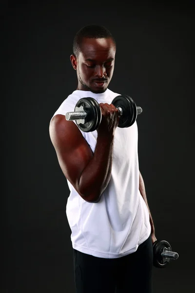 Bonito homem africano de esportes sobre fundo preto — Fotografia de Stock