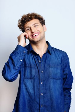 Mavi backgorund kıvırcık saçlı yakışıklı adam