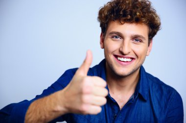 Mavi backgorund kıvırcık saçlı yakışıklı adam