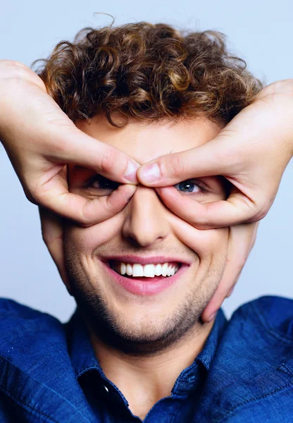 Handsome man with curly hair on blue backgorund — Stock Photo, Image