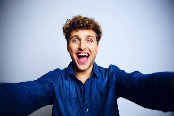 Bonito homem com cabelo encaracolado em azul backgorund — Fotografia de Stock