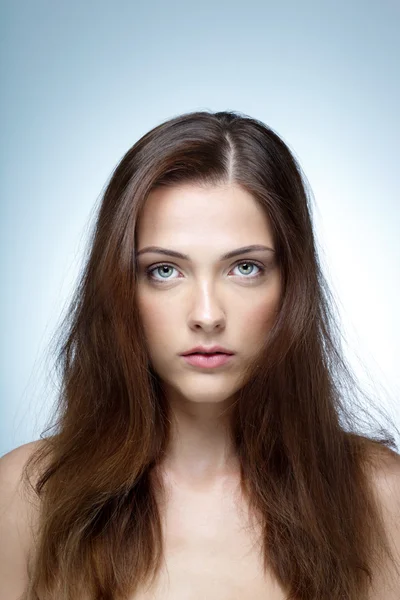 Retrato de uma mulher de beleza isolada em um fundo azul — Fotografia de Stock