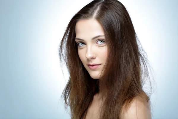 Retrato de uma mulher de beleza isolada em um fundo azul — Fotografia de Stock