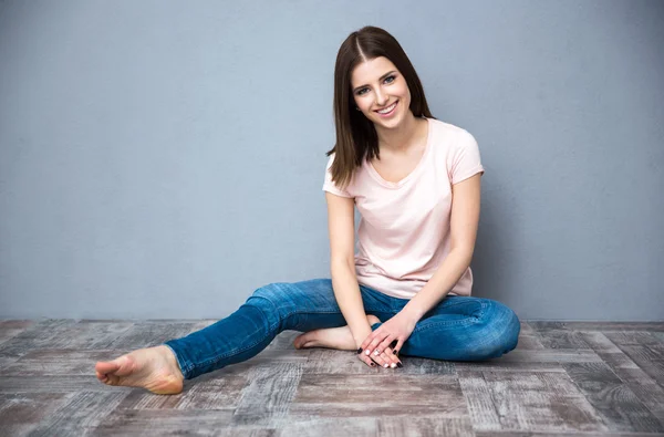 Nette Frau sitzt auf dem Fußboden — Stockfoto