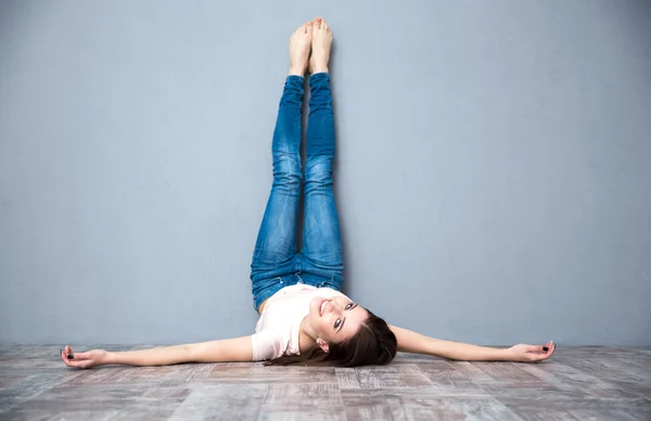 Woman lying on the floor with legs raised up — Stock Photo, Image