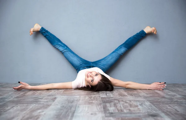 Женщина лежит на полу с поднятыми ногами — стоковое фото