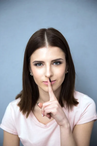 Vrouw met vinger over lippen — Stockfoto