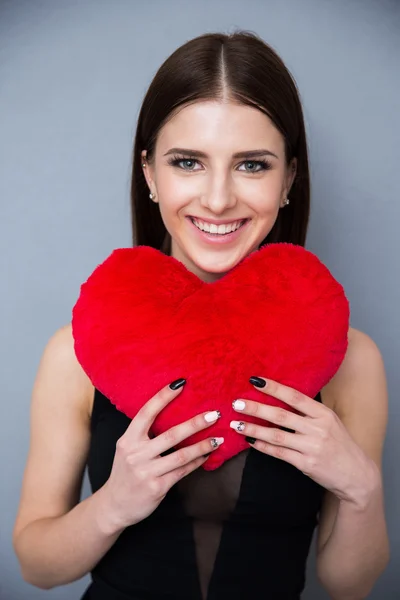 Smiling young woman holding red heart — Stock Photo, Image