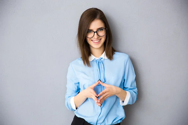 Lächelnde Geschäftsfrau mit Brille vor grauem Hintergrund — Stockfoto