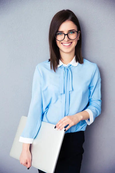 Retrato de uma mulher de negócios feliz segurando laptop — Fotografia de Stock