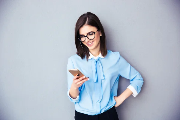 Glimlachende zakenvrouw met smartphone — Stockfoto