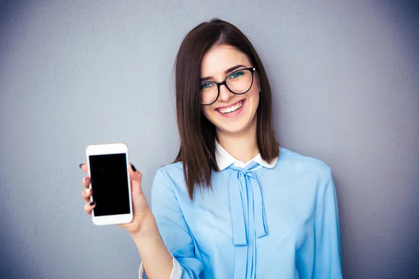 Feliz mujer de negocios mostrando pantalla de teléfono inteligente en blanco — Foto de Stock