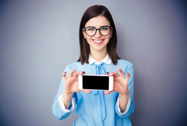 Empresária sorridente mostrando tela de smartphone em branco — Fotografia de Stock