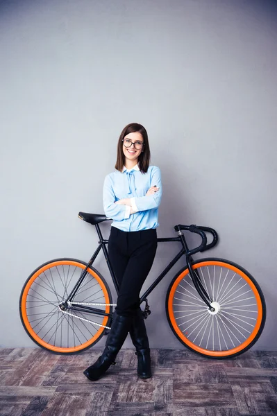 Glimlachende zakenvrouw permanent in de buurt van fiets — Stockfoto